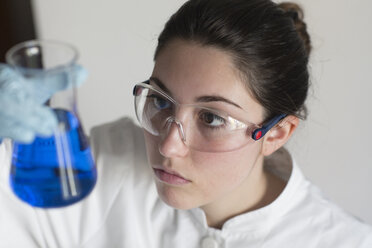 Lab technician examining liquid - SGF000824