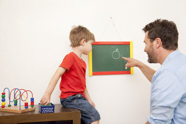 Vater und Sohn zeichnen auf eine Tafel - MMF000283