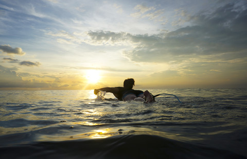 Indonesia, Bali, Canggu, young woman at her surfboard by twilight stock photo