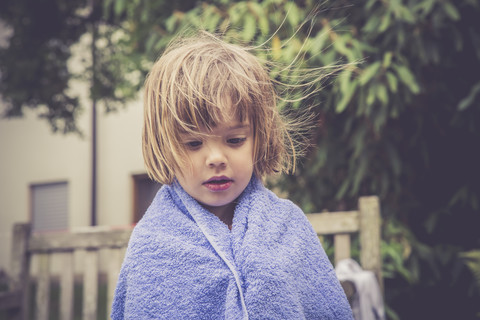 Tagträumendes kleines Mädchen in ein Handtuch gewickelt, lizenzfreies Stockfoto