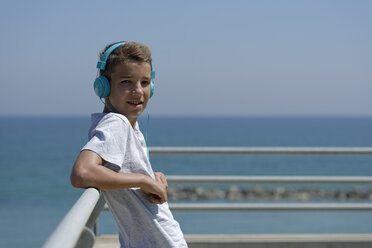 Porträt eines Teenagers mit Kopfhörern vor dem Meer - LBF000857