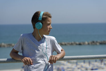 Porträt eines Teenagers mit Kopfhörern vor dem Meer - LBF000858