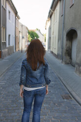 Rear view of brunette woman in a street - HCF000048