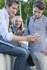 Gruppe von Freunden im Freien mit Mobiltelefonen - UUF001368