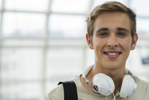 Porträt eines jungen Mannes mit Kopfhörern an einer S-Bahn-Station - UUF001447