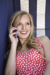 Portrait of smiling young woman telephoning with smartphone - GDF000363