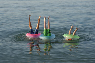 Italien, Adria, Kinder tauchen im Meer mit einem schwimmenden Reifen - LBF000859