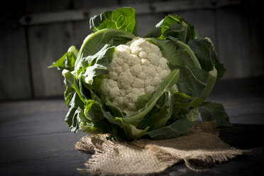 Blumenkohl auf Jute und Holztisch - MAEF008811