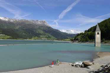 Italien, Südtirol, Vinschgau, Alter Kirchturm von Graun am Reschensee, Zwei Kinder - LBF000828