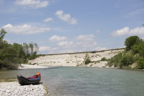 Germany, Bavaria, little rafting boat lying on rocky beach at waterside of Isar River - TKF000373