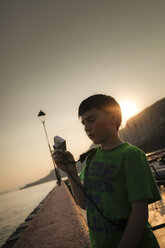 Italien, Venetien, Garda, Gardasee, Junge fotografiert bei Sonnenuntergang - SBDF001049