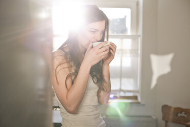 Porträt einer jungen Frau beim Teetrinken am Morgen - FEXF000148