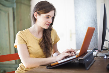 Young woman using her laptop at home - FEXF000231