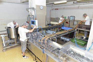 Germany, Saxony-Anhalt, workers at production line in a baking factory - LYF000235