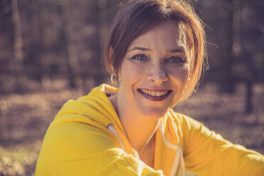 Deutschland, Hessen, Lampertheim, Frau ruht sich nach sportlicher Betätigung im Wald aus, Portrait - UUF001489