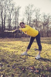 Deutschland, Hessen, Lampertheim, Frau beim Sport mit einem Ast im Wald - UUF001512