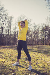 Deutschland, Hessen, Lampertheim, Frau beim Sport im Wald, Stretching - UUF001513