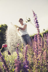 Mature woman watering flowers - UUF001476