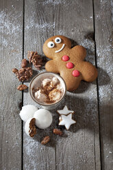 Gingerbread man, Christmas cookies and a mug of cocoa with cream on grey wood - CSF021991