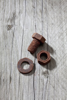 Schraube, Innenschraube und Zahnrad aus Schokolade auf grauem Holz liegend - CSF022014