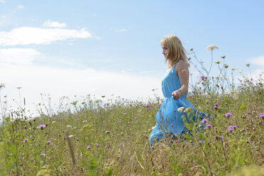 Young woman on wildflower meadow - BFRF000474