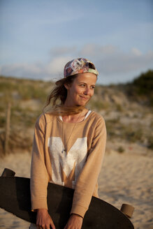 France, Aquitaine, Seignosse, portrait of female long boarder on the beach at twilight - FAF000029