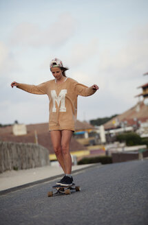 Frankreich, Aquitaine, Seignosse, Frau beim Longboarden auf der Straße - FAF000030