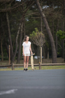 France, Aquitaine, Seignosse, woman waiting with her longboard - FAF000035