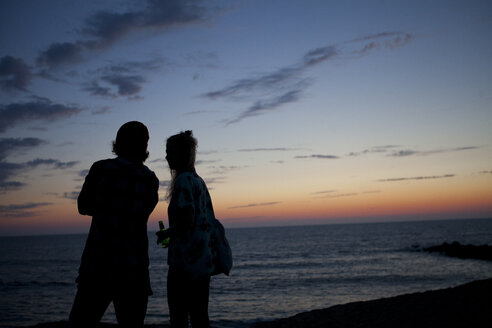 France, Aquitaine, silhouette of couple watching the sea at twilight - FAF000036