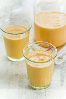 Flasche und zwei Gläser Mango-Orangen-Karotten-Smoothie - SBDF001110