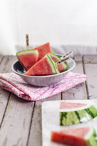 Schale und Teller mit Melonen-Eis am Stiel auf Stoff und Holz, lizenzfreies Stockfoto