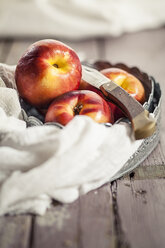 Bowl of nectarines and a knife on cloth and wood - SBDF001119