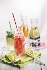 Carafes of miscellaneous fruit infused water on cloth and wood - SBDF001126