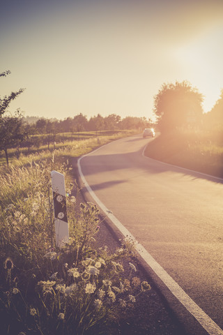 Driving car on country lane at evening twilight stock photo