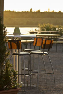 Saxony, empty chairs in a beer garden at evening twilight - MELF000011