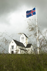 Island, Blick auf die Kirche von Skalholt mit wehender Nationalflagge am Fahnenmast im Vordergrund - FCF000358