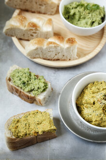 Schalen mit Erbsen-Koriander- und Karotten-Fenchel-Hummus, Fladenbrotscheiben auf Metall - EVGF000730