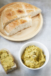 Bowl of carrot fennel hummus and slices of flat bread on metal, elevated view - EVGF000733