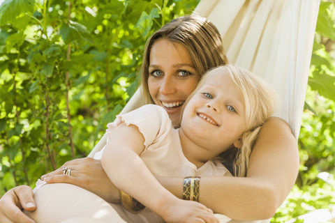 Mother and daughter relaxing in hammock stock photo