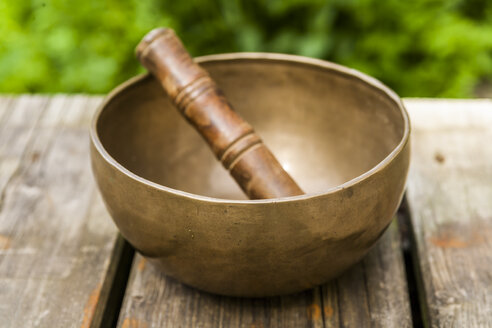 Singing bowl on wooden terrace - TCF004170