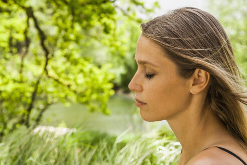 Woman with closed eyes outdoors - TCF004145