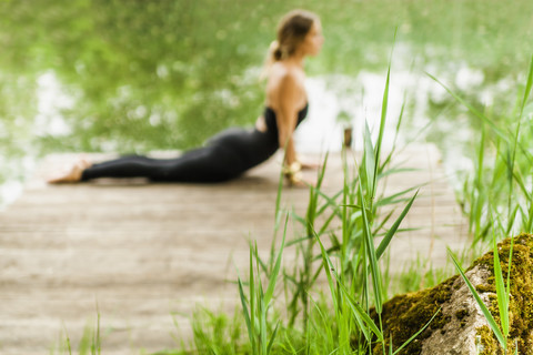 Woman practicing yoga on jetty stock photo