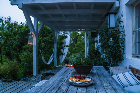 Terrassentisch mit Kerzen in der Abenddämmerung, lizenzfreies Stockfoto