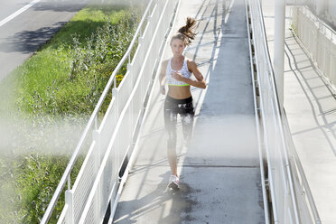 Deutschland, München, Joggerin läuft auf einer Brücke - MAEF008867