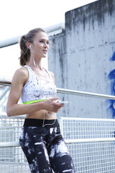 Germany, Munich, Female jogger listening music - MAEF008900