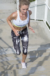 Germany, Bavaria, Munich, Female jogger on the stairs - MAEF008870