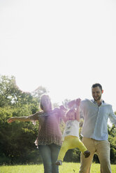 Parents and little daughter having fun on a meadow - UUF001529