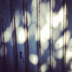 Licht und Schatten an einem sonnigen Sommertag an einer Garagenwand - HAWF000417
