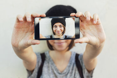 Junge Skateboarderin versteckt sich hinter ihrem Smartphone mit ihrem Selfie - EBSF000281