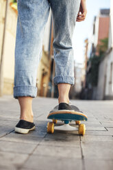 Young female skate boarder on her skateboard, partial view - EBSF000286